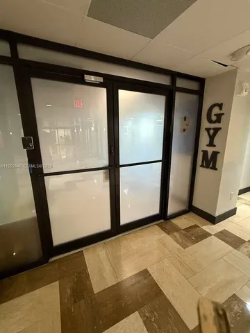 a view of a hallway to room with wooden floor