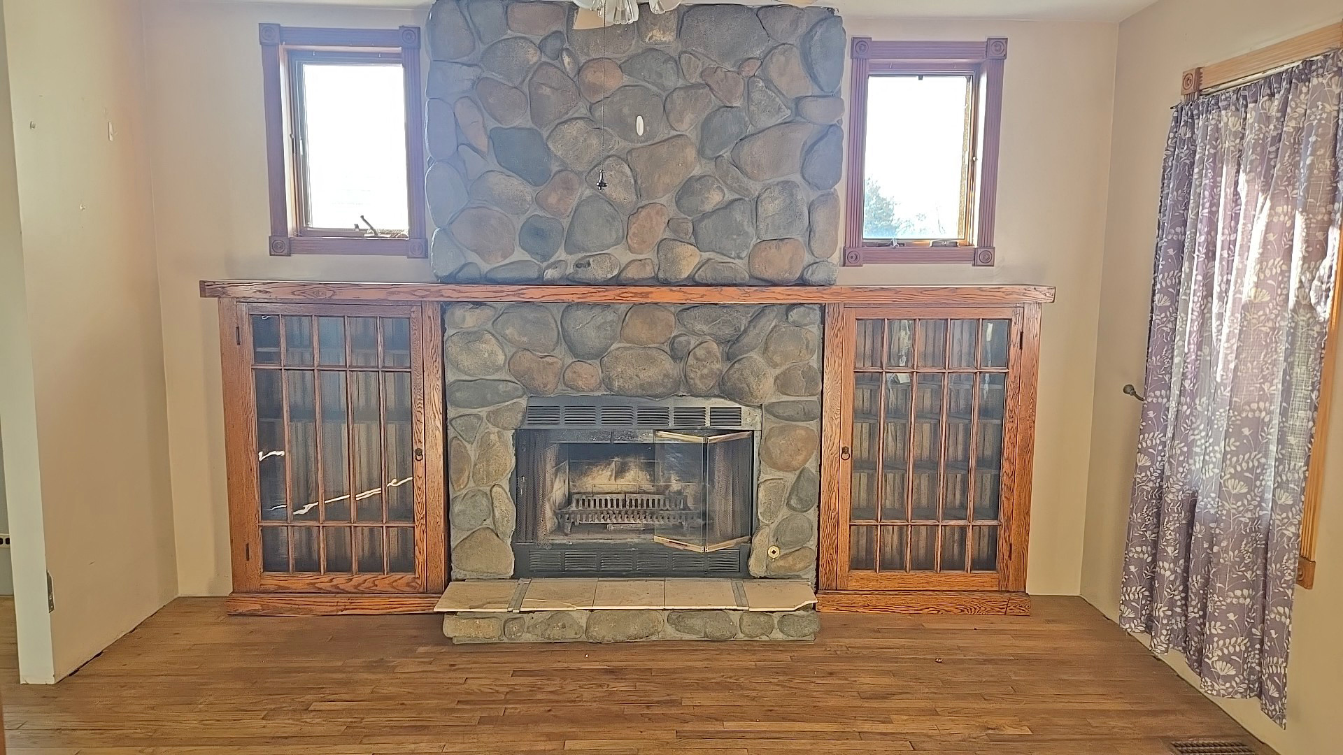 3417 Butler Avenue Steger, IL 60475 - Photo 7 of 22 an empty room with wooden floor fireplace and windows
