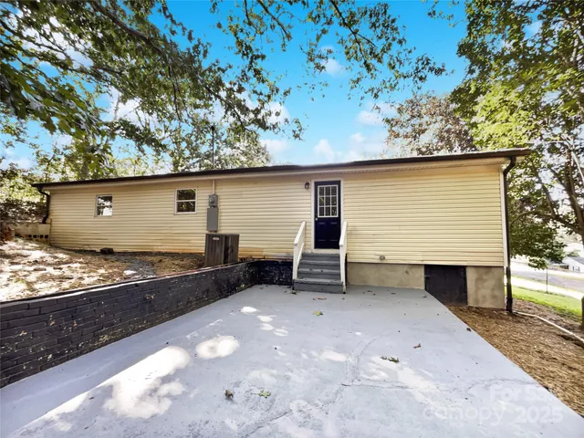 a backyard of a house with barbeque oven and table