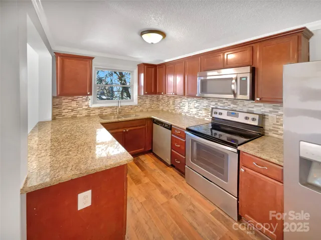 a kitchen with stainless steel appliances granite countertop a sink stove and refrigerator