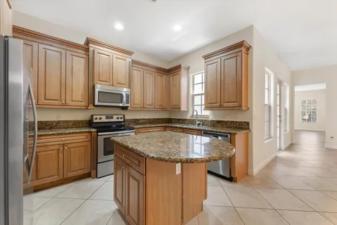 a kitchen with stainless steel appliances granite countertop a stove a sink and a microwave