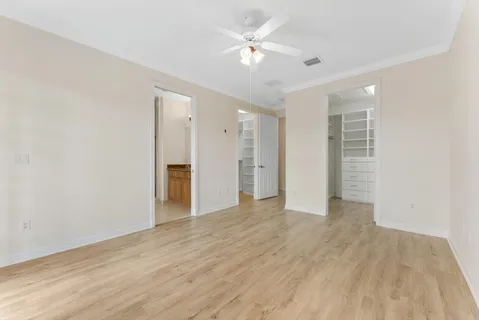 wooden floor in an empty room with a ceiling fan