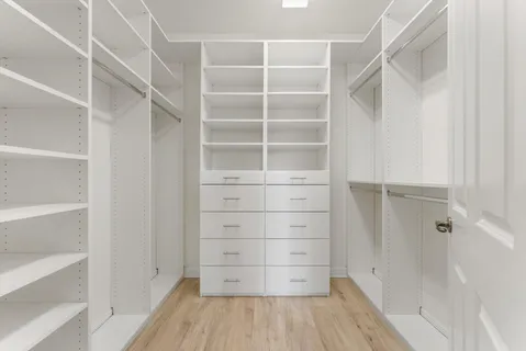 a view of walk in closet with empty racks