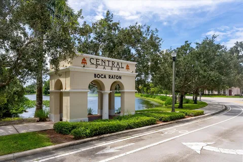 a view of a white house with a yard and large trees