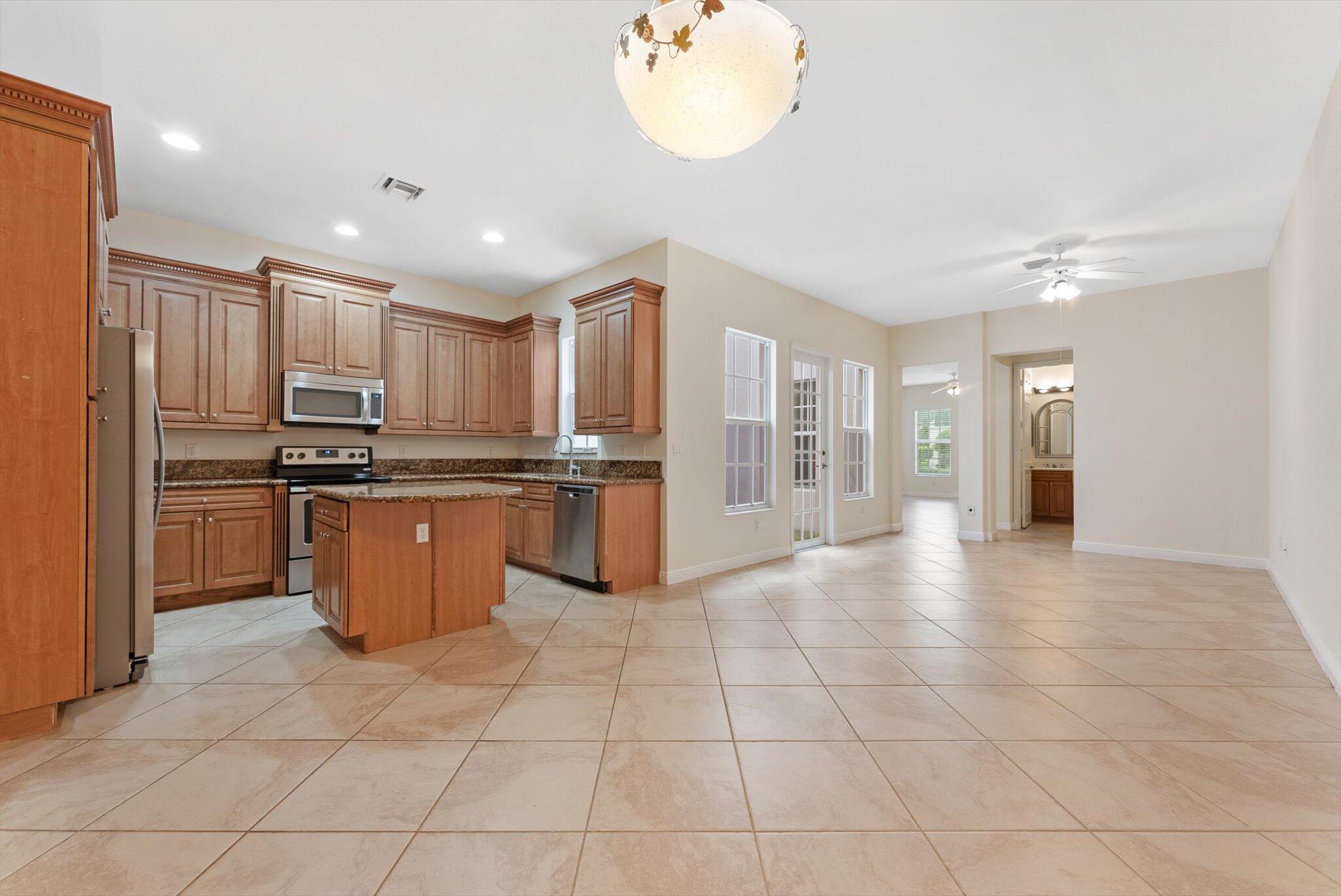 806 Northwest 83rd Lane Boca Raton, FL 33487 - Photo 9 of 37 a kitchen with stainless steel appliances granite countertop a refrigerator and a sink