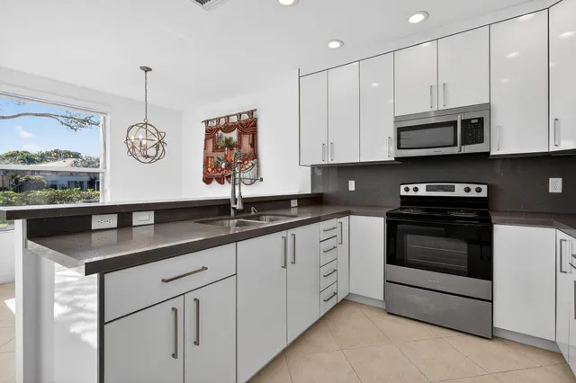 a kitchen with granite countertop white cabinets and a sink