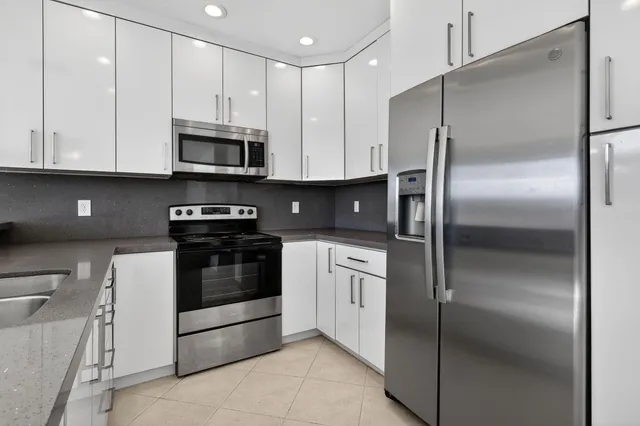 a kitchen with stainless steel appliances a refrigerator sink and microwave