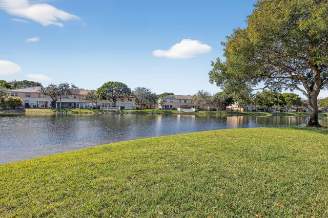 an aerial view of residential houses with outdoor space and lake view in back