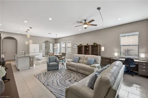 a living room with furniture a ceiling fan and a window