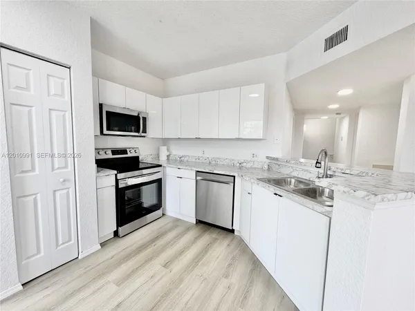 a kitchen with a sink stove and microwave