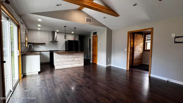 a view of kitchen with refrigerator and wooden floor