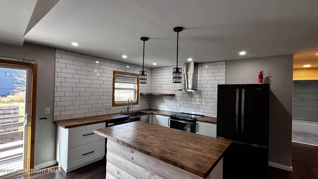 a kitchen with stainless steel appliances granite countertop a sink a stove and a refrigerator