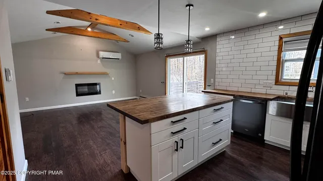 an empty room with wooden floor chandelier fan and windows