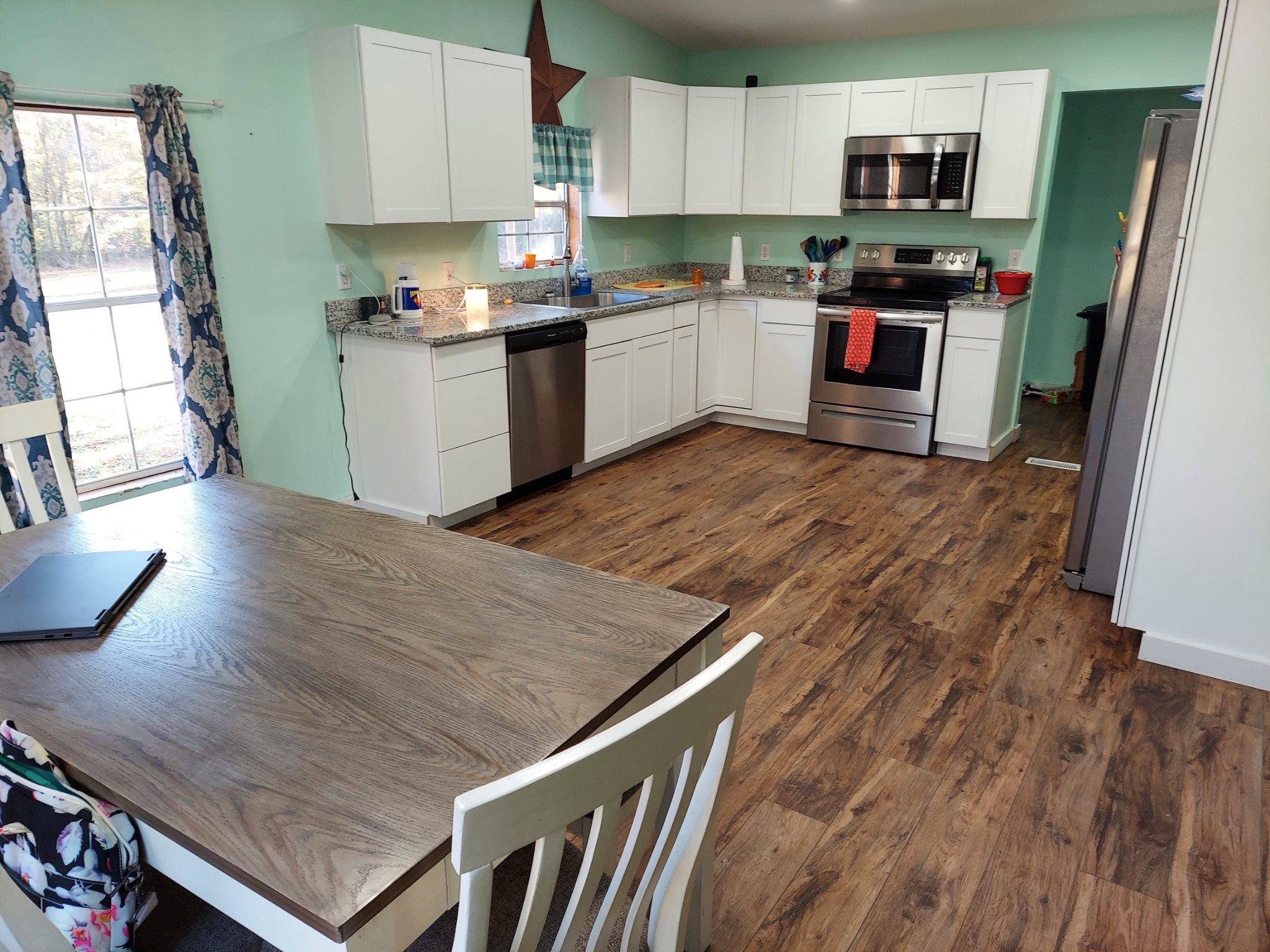 985 Pruett Springs Road Dickson, TN 37055 - Photo 22 of 35 a kitchen with granite countertop a stove top oven a sink dishwasher and a refrigerator with wooden floor