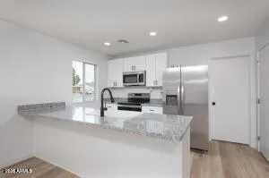 a kitchen with granite countertop a refrigerator and a sink