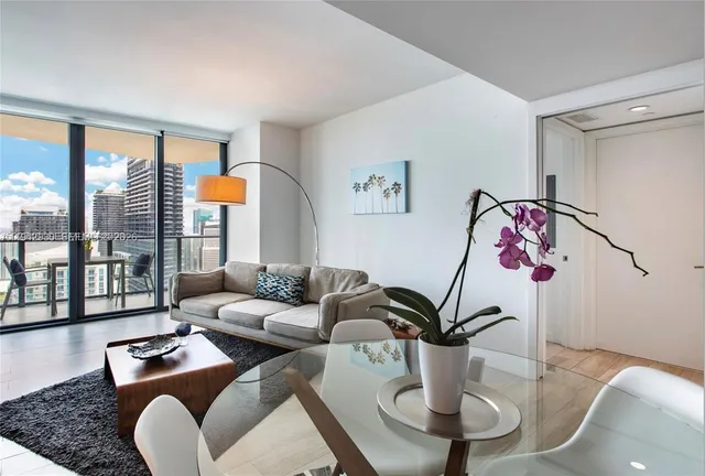 a living room with furniture and a floor to ceiling window