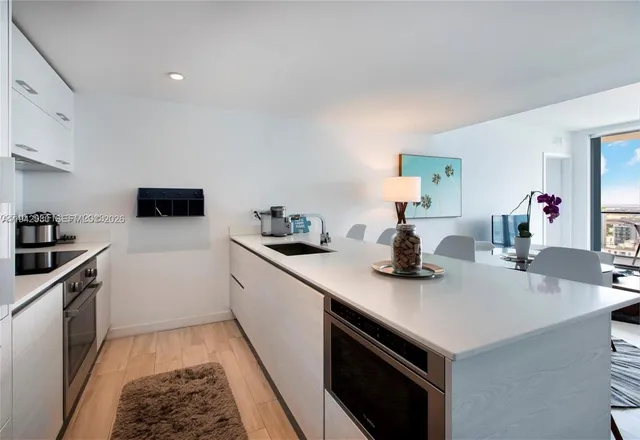 a kitchen with a sink and white cabinets