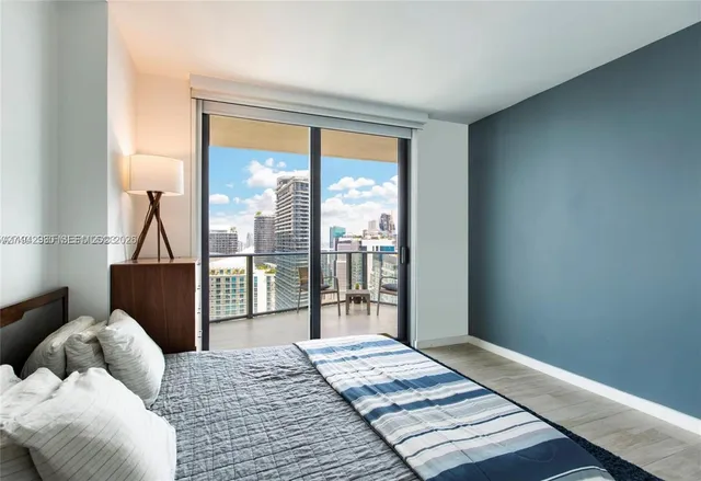 a bedroom with a bed and a large window