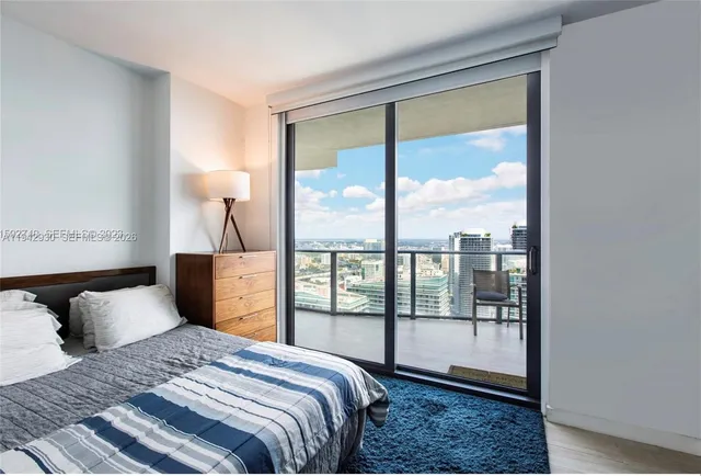 a bedroom with a large bed and a balcony view