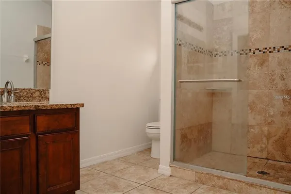 a bathroom with a granite countertop shower and a toilet