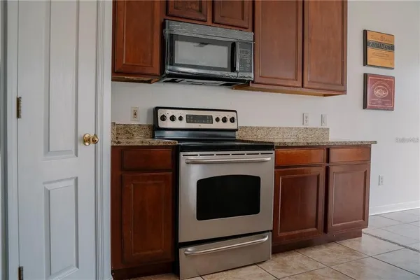 a kitchen with stainless steel appliances granite countertop a stove microwave and sink