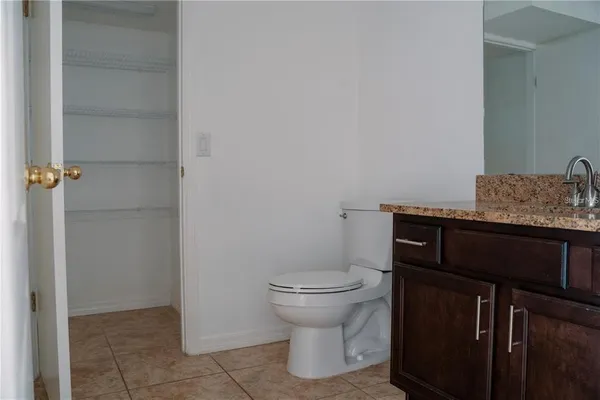 a bathroom with a granite countertop sink and toilet
