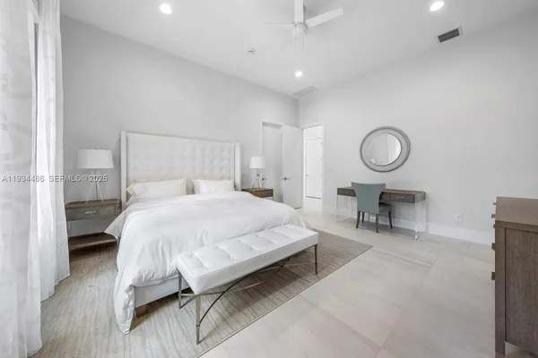 a spacious bedroom with a bed and a chandelier