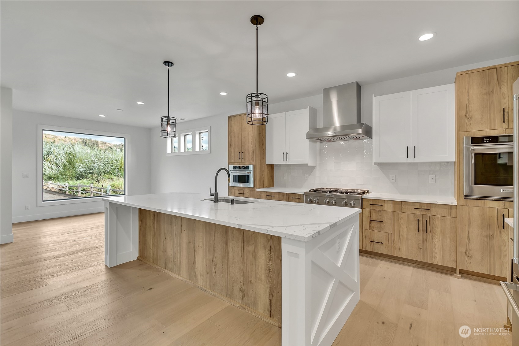 5425 Parker Road East Sumner, WA 98390 - Photo 13 of 40 a kitchen with stainless steel appliances granite countertop a sink a stove and a wooden floors