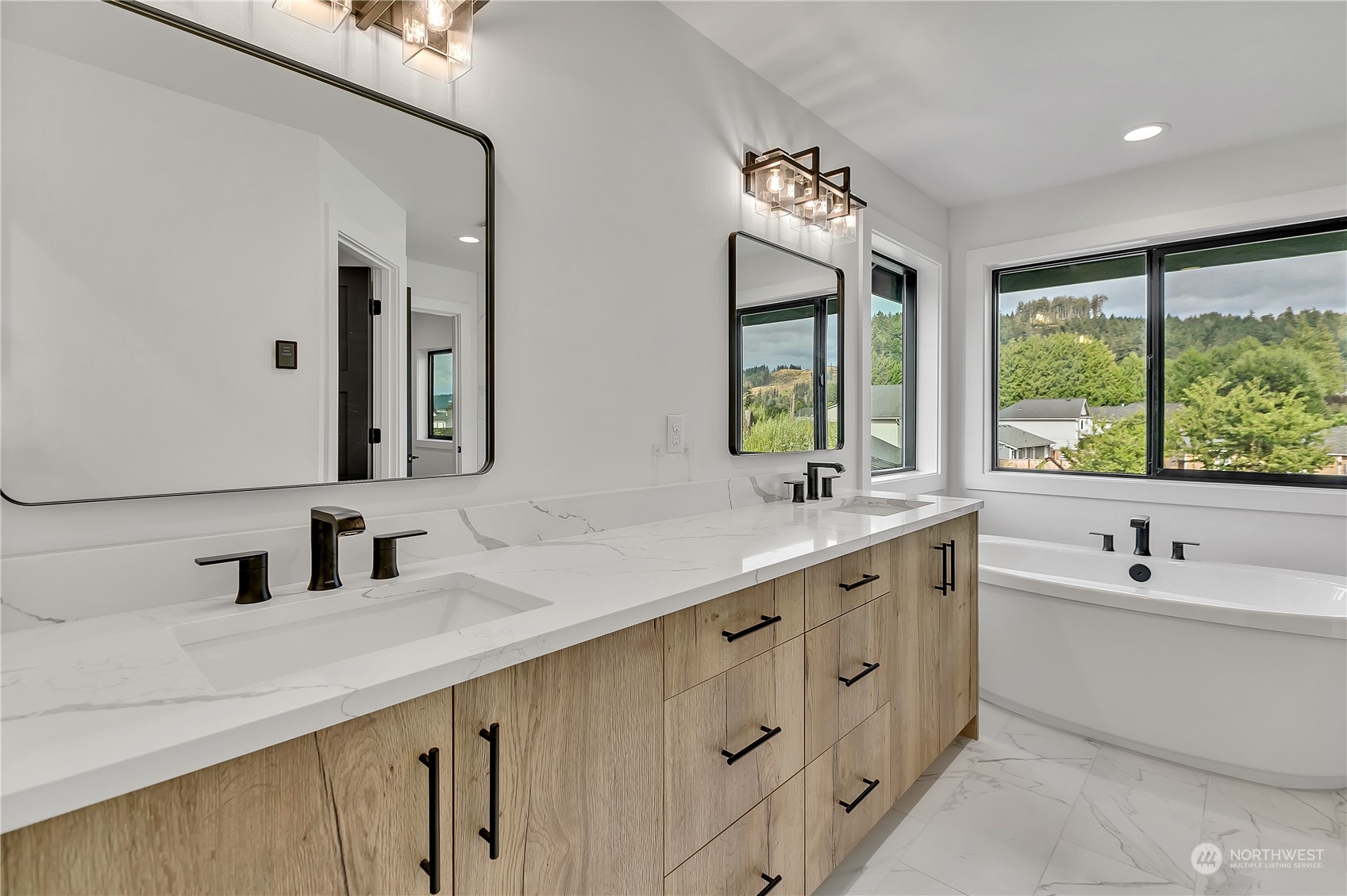 5425 Parker Road East Sumner, WA 98390 - Photo 30 of 40 a bathroom with a double vanity sink a large mirror and a bathtub