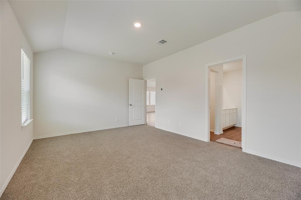 3407 Rendezvous Way Sherman, TX 75090 - Photo 13 of 17 Spacious room featuring vaulted ceilings, light-colored carpeting, a window with horizontal blinds, and a white paneled door