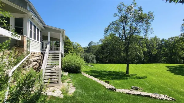a view of a house with a yard and tree s