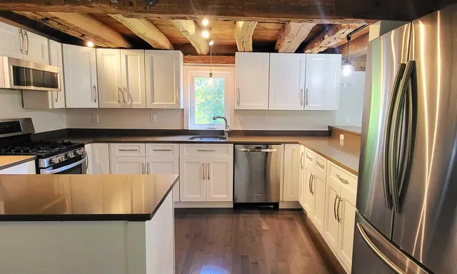 a kitchen with white cabinets and stainless steel appliances