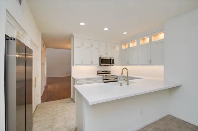 a kitchen with kitchen island a sink stainless steel appliances and cabinets