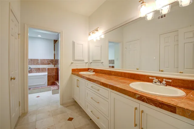 a spacious bathroom with a sink double vanity and a mirror
