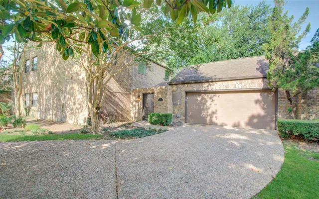 a view of a house with a yard and large tree