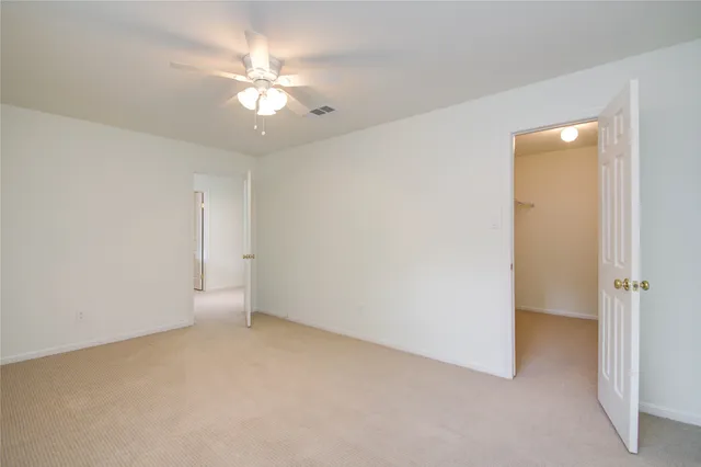 an empty room with a ceiling fan and a window