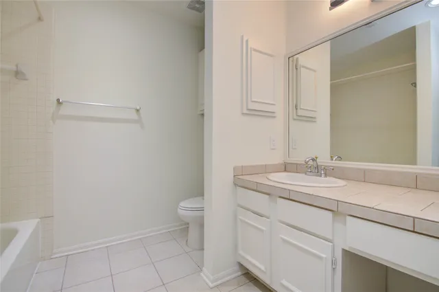 a bathroom with a granite countertop sink a toilet and a mirror