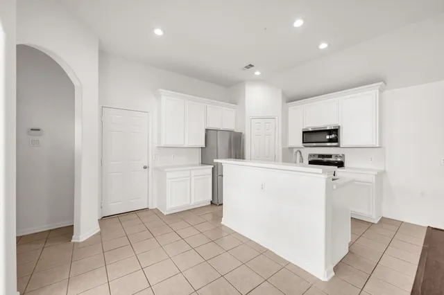 a kitchen with white cabinets and white appliances