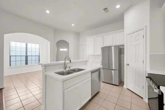 a kitchen with a refrigerator sink and cabinets