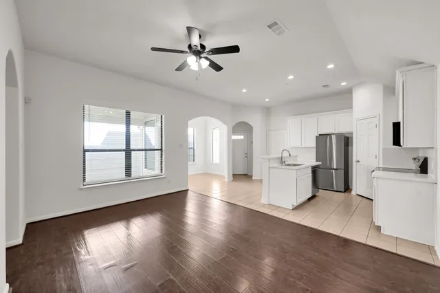 a view of a kitchen with fridge and wooden floor