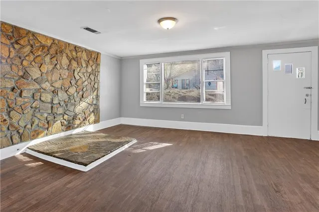 a kitchen with stainless steel appliances granite countertop white cabinets a sink a window a wooden floor and a sink