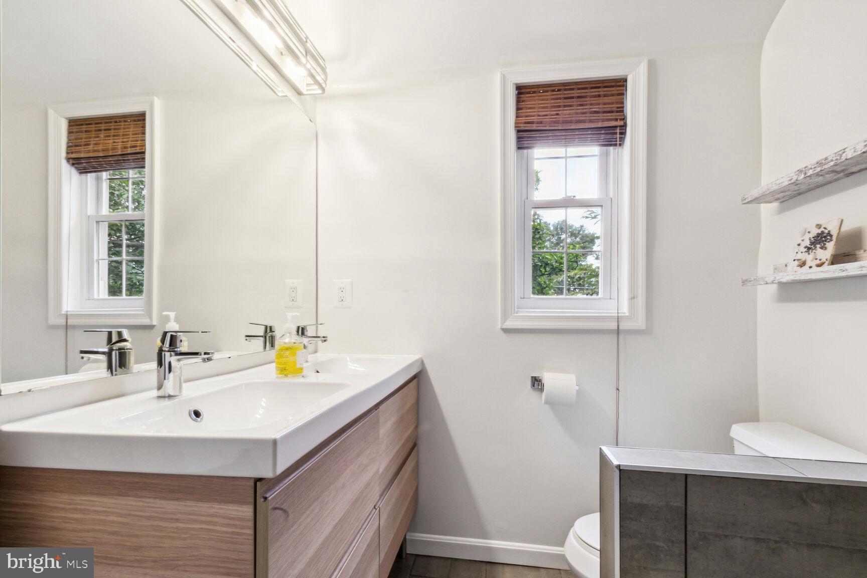 8504 Grubb Road Chevy Chase, MD 20815 - Photo 17 of 29 a bathroom with a sink a toilet and a mirror
