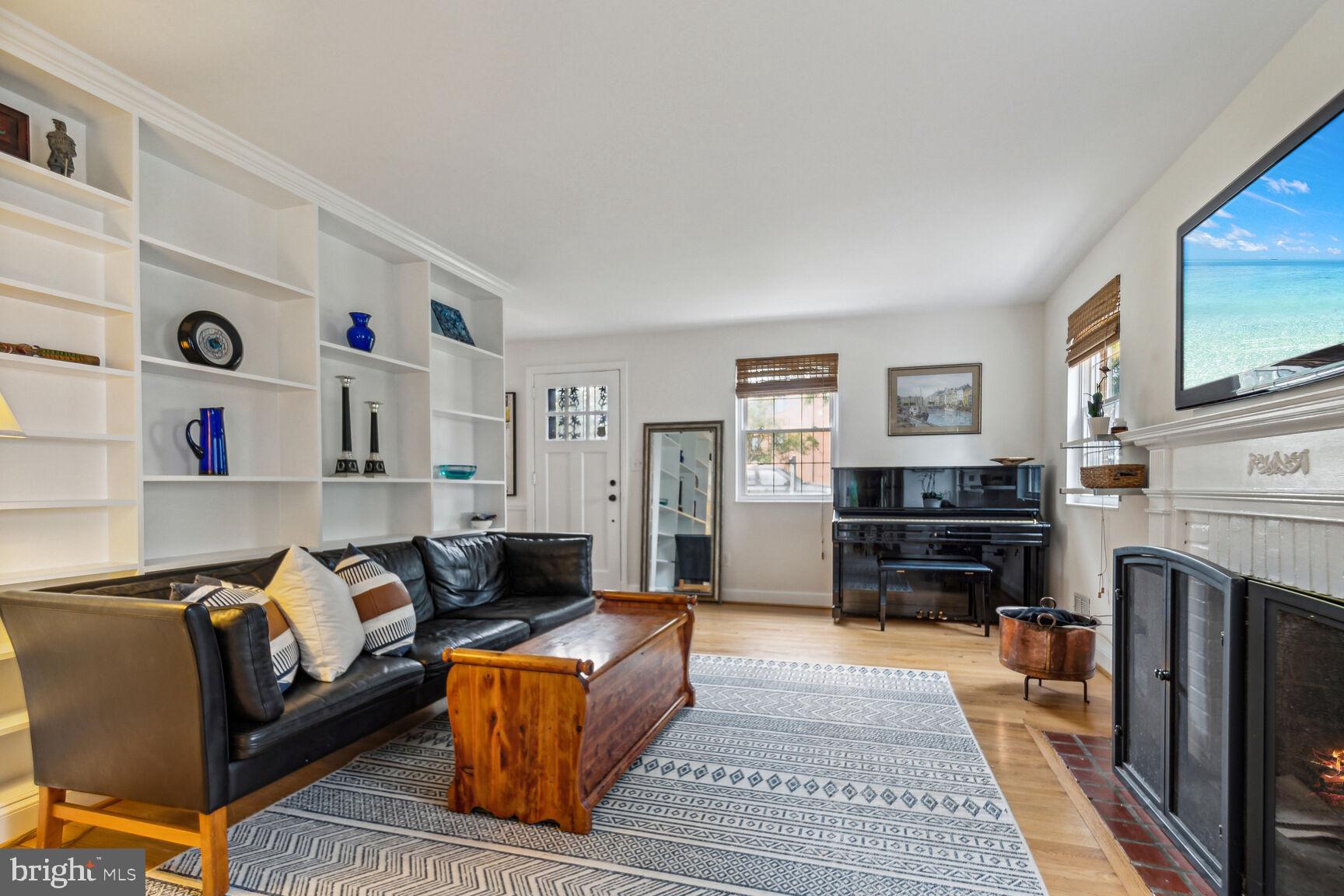 8504 Grubb Road Chevy Chase, MD 20815 - Photo 3 of 29 a living room with furniture a fireplace and a flat screen tv