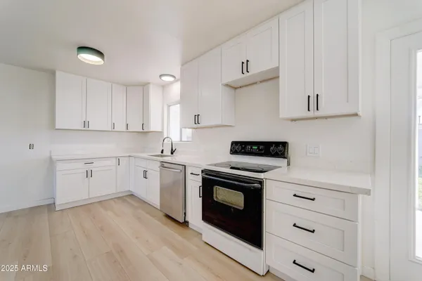 a kitchen with granite countertop a stove top oven sink and cabinets