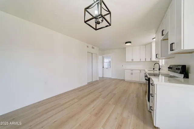 a view of a kitchen with wooden floor and cabinets