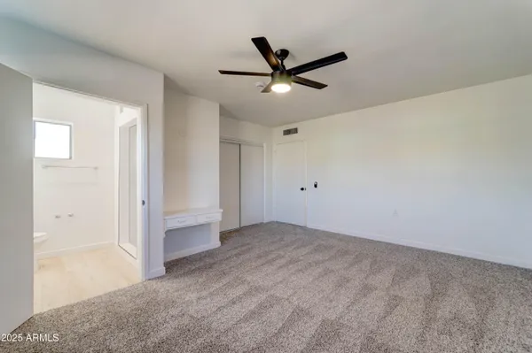 a view of a big room with wooden floor and windows