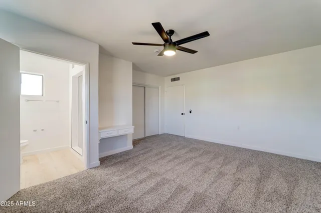 a view of a big room with wooden floor and windows