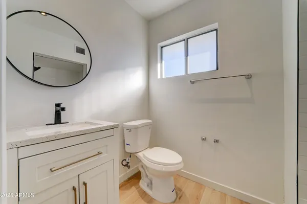 a bathroom with a toilet a sink and mirror
