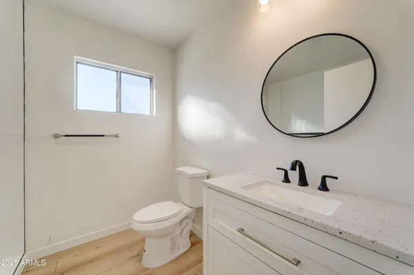 a bathroom with a toilet a sink a mirror and vanity