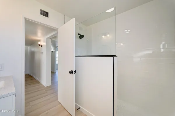a bathroom with a shower and a glass door